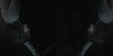 angela holding a knife looking into a mirror