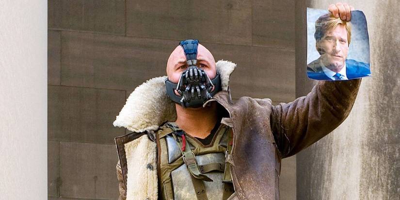 tom hardy as bane with a photo of harvey dent