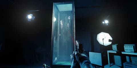 Sebastian aiming a gun at a glass chamber with the ghosts of three women inside