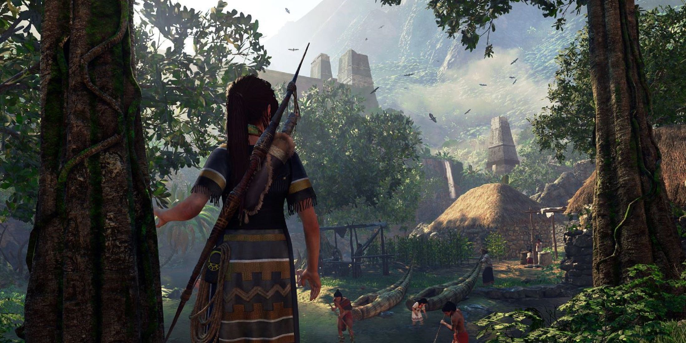 Lara Croft stands at the edge of a lush jungle village in Shadow of the Tomb Raider.