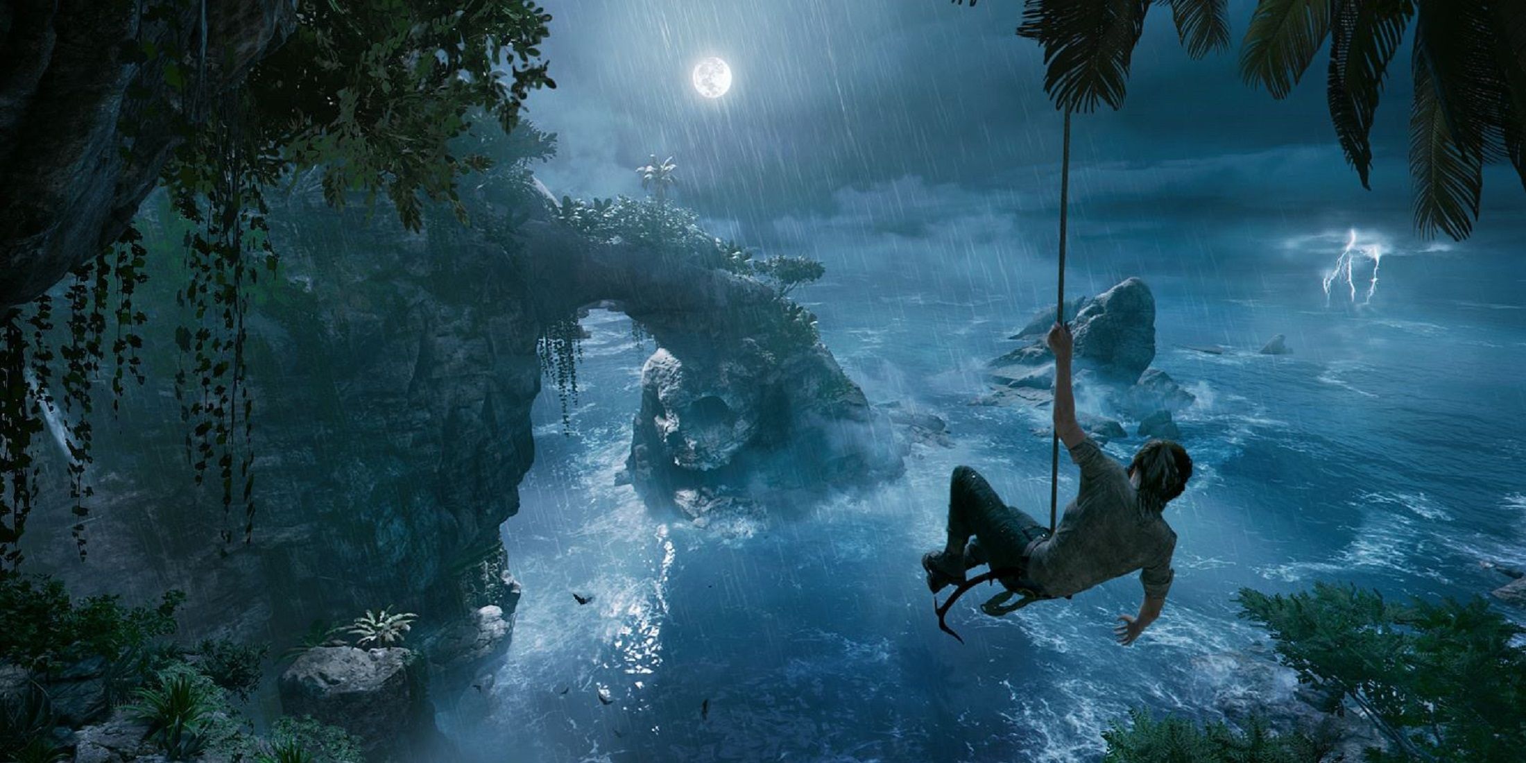 Lara Croft swings on a rope above a stormy coastline in Shadow of the Tomb Raider