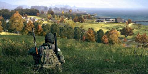 DayZ player crouching on a hilling overlooking the coastline