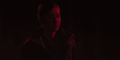 Kiran Estevez covered in a red light in Alan Wake 2 The Lake House DLC