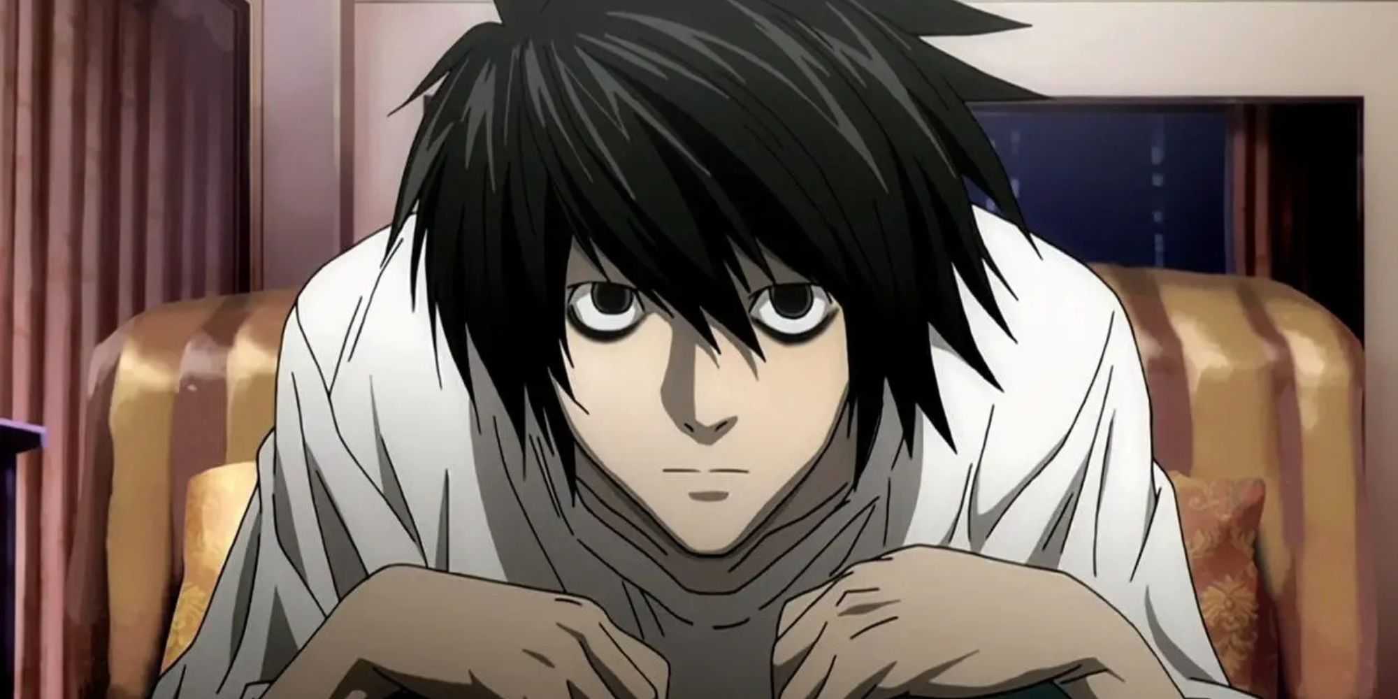 L hunched over in a chair in Death Note
