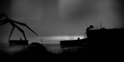 A young boy climbing up a ledge to run from a giant spider in Limbo