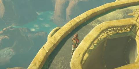 a rocky coastline with azure seawater, a causeway above.