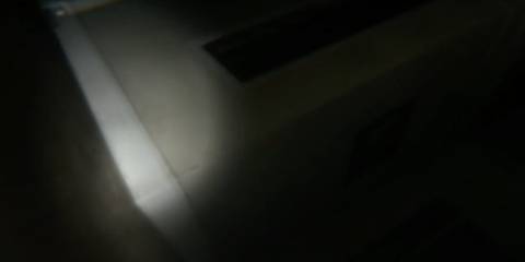 The corner of a corridor illuminated by a single light