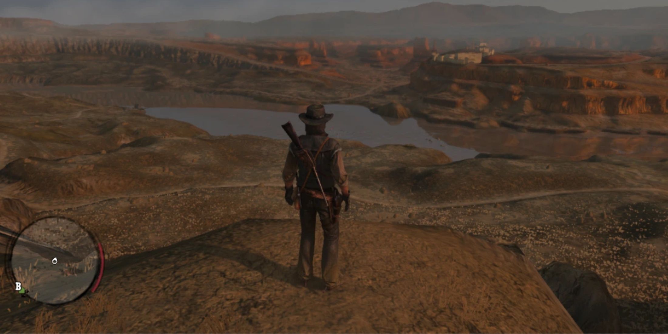 John Marston standing on a cliff side overlooking a valley in Red Dead Redemption