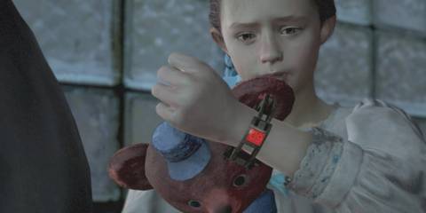 Natalia wearing a fear bracelet and holding her teddy bear