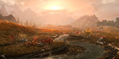 A scenic view of Skyrim’s wilderness with mountains in the background in The Elder Scrolls V: Skyrim