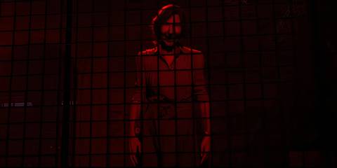 The Quarry Lim Shaye in red room, smiling through cell bars