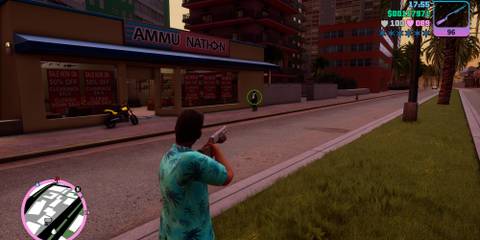 Tommy Verceti aiming a shotgun at a pedestrian in front of the Ammu Nation in Grand Theft Auto Vice City.