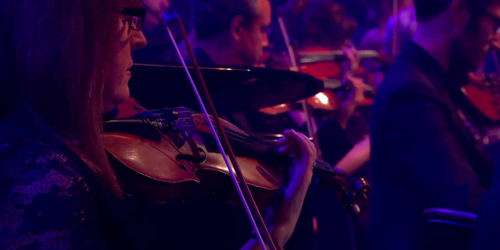 A Frame Showing A Violinist From The PlayStation In Concert Performance