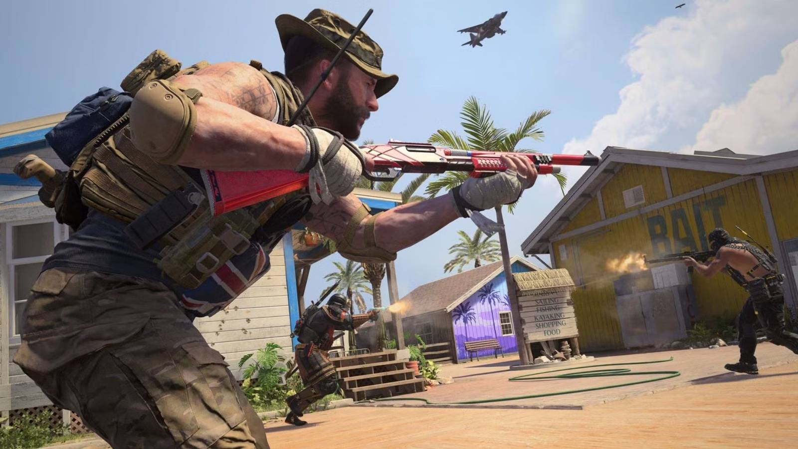 A man in a hat holds a red shotgun.