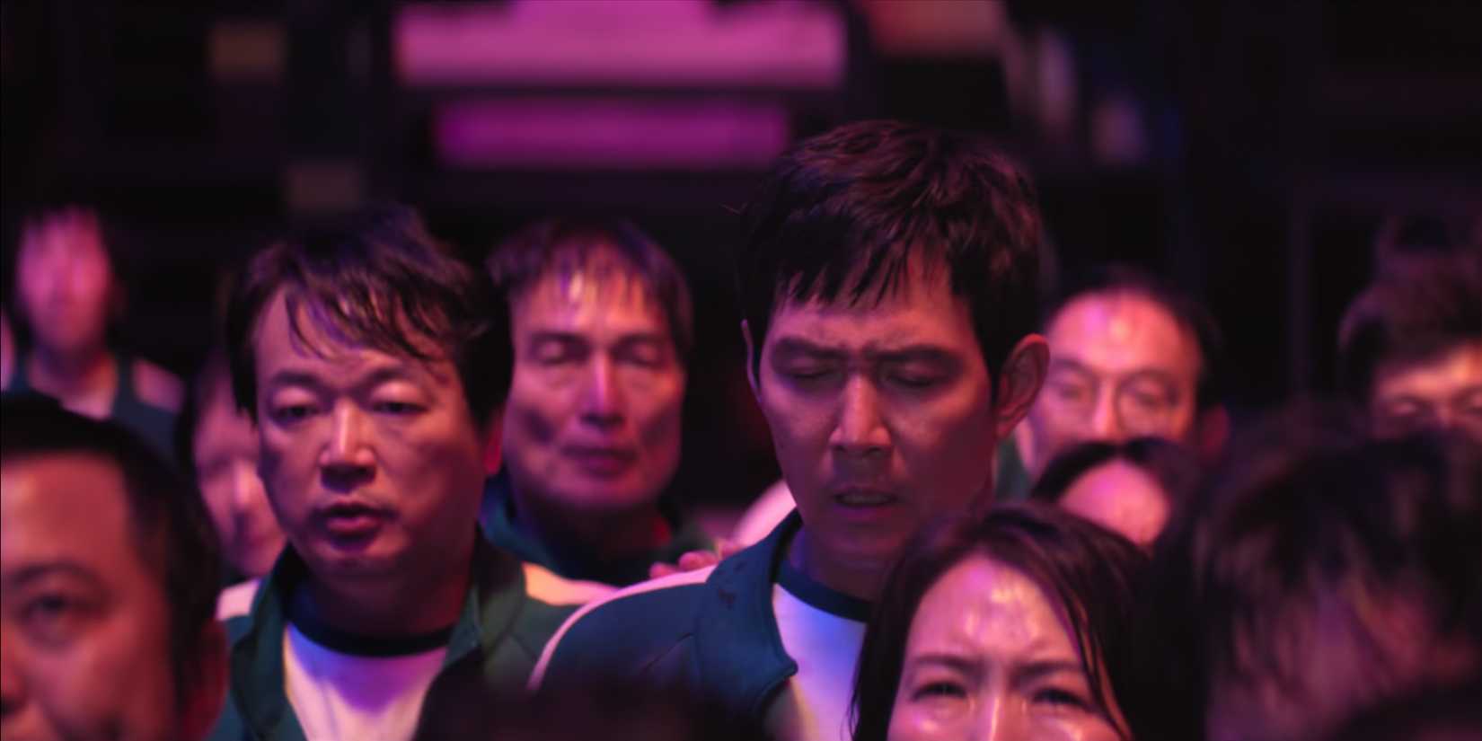 Gi-hun and Jung-bae anxiously observe the first vote in Squid Game.