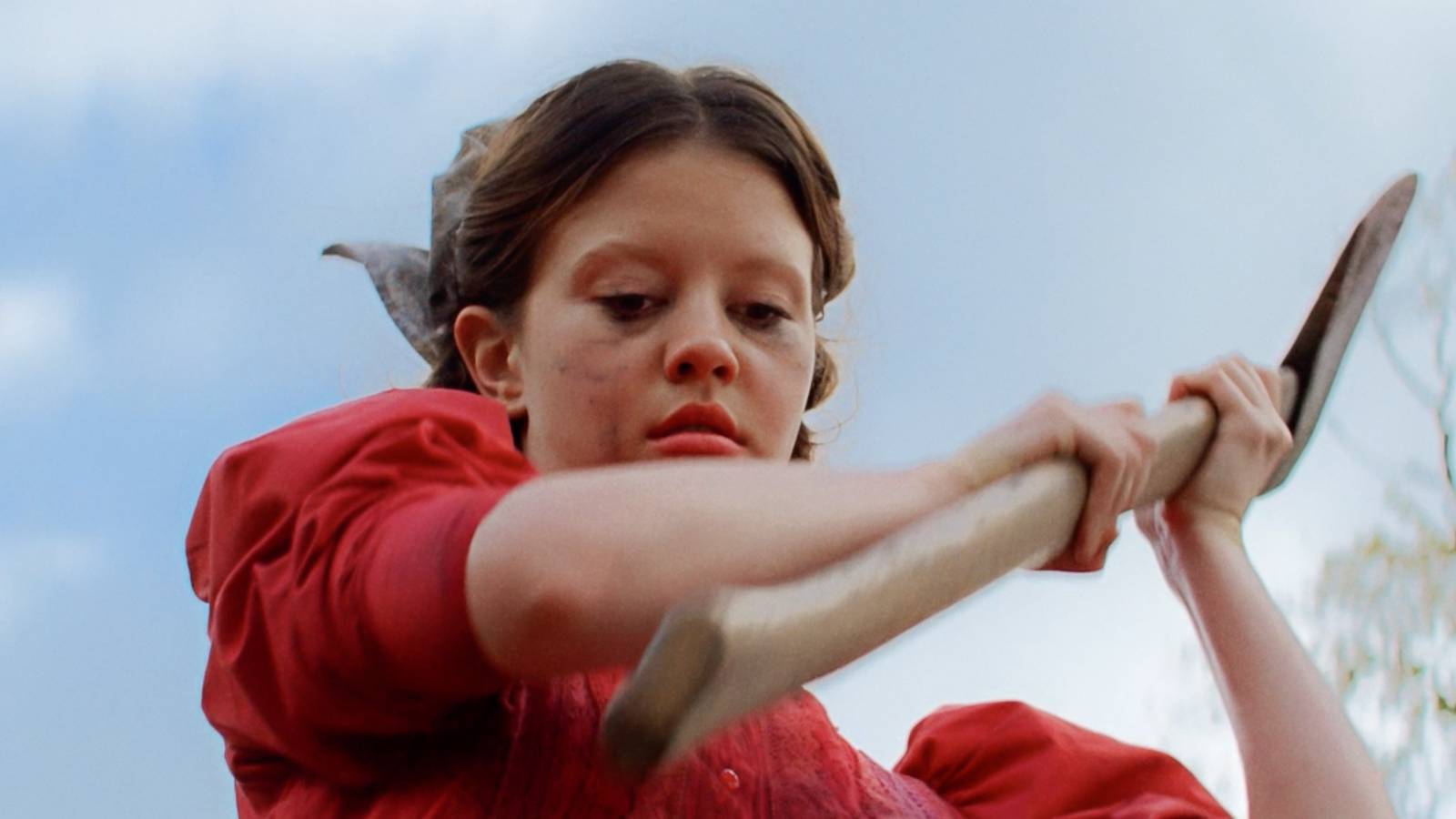 Pearl (Mia Goth) raising an axe in Pearl (2022)