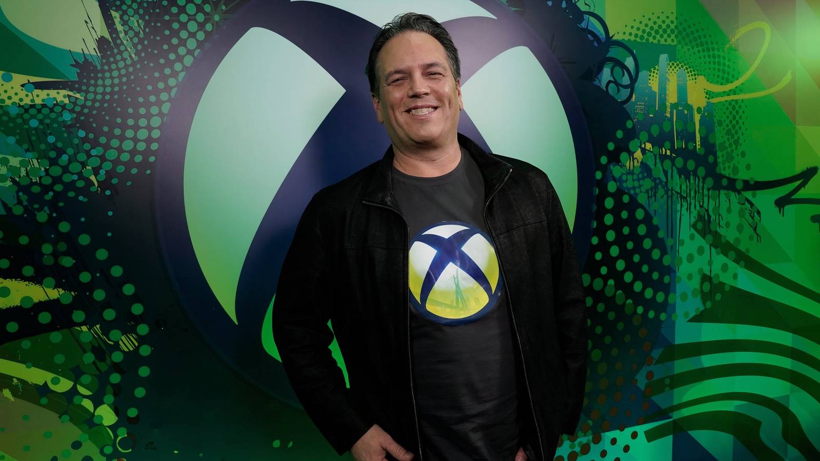Phil Spencer showing PlayStation and Nintendo logos at Developer Directs