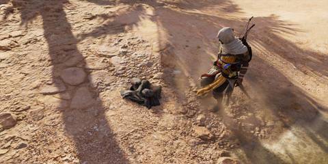 Bayek looking at a bundle of clothes in Assassin's Creed Origins