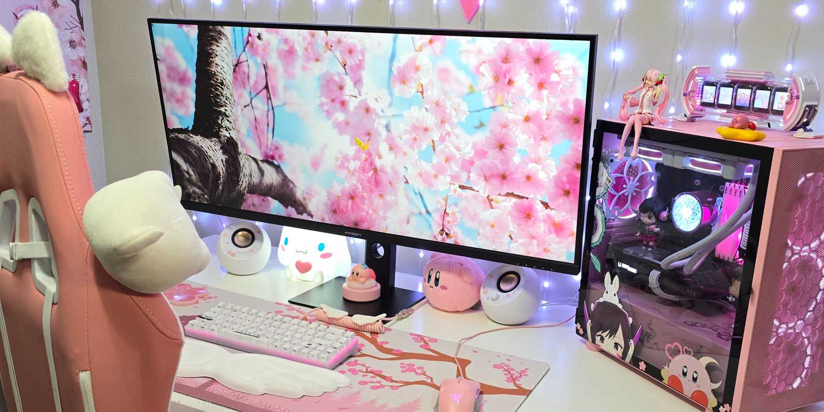 Pink-themed gaming setup with an ultrawide monitor and PC