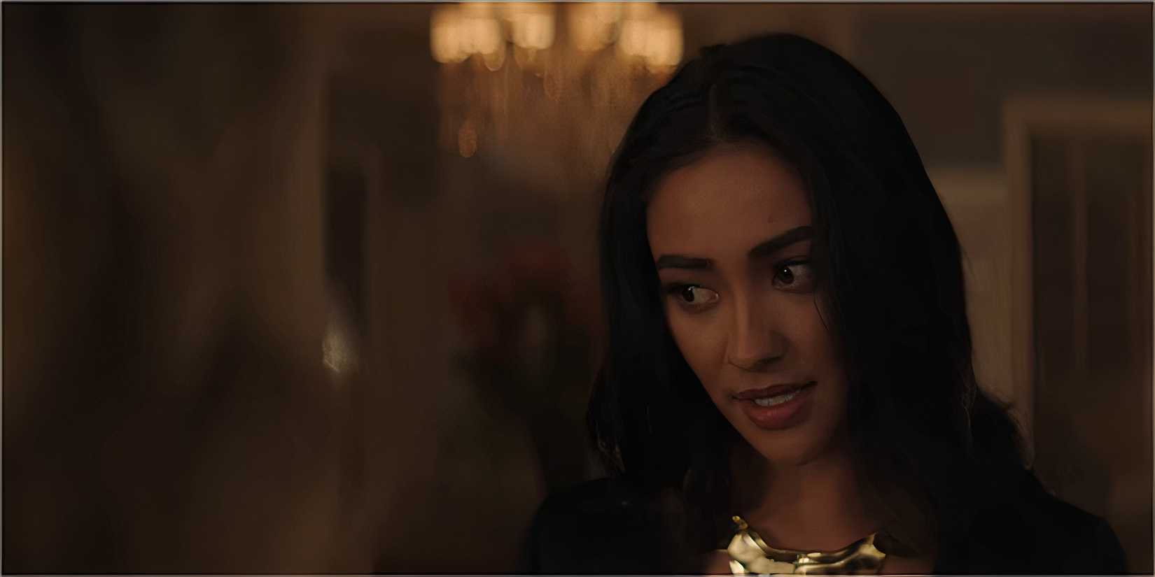 A woman in a black outfit gives a sly look