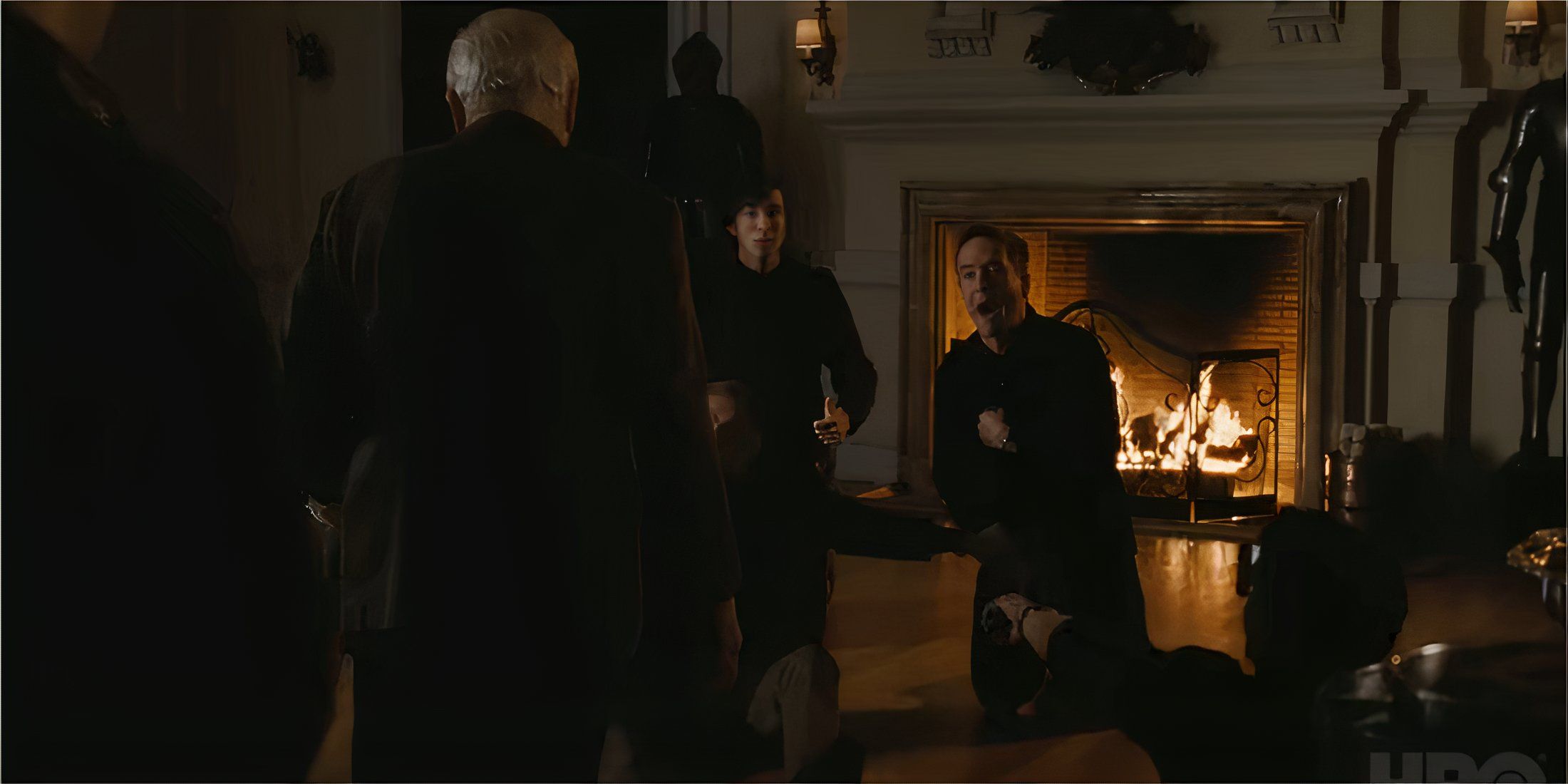 Executives crawl for sausages in Succession S2E2 by a fireplace.