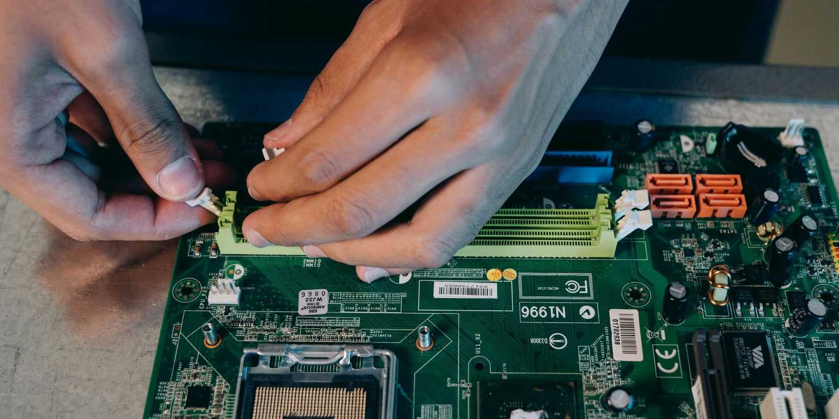 Image of a person handling a motherboard.
