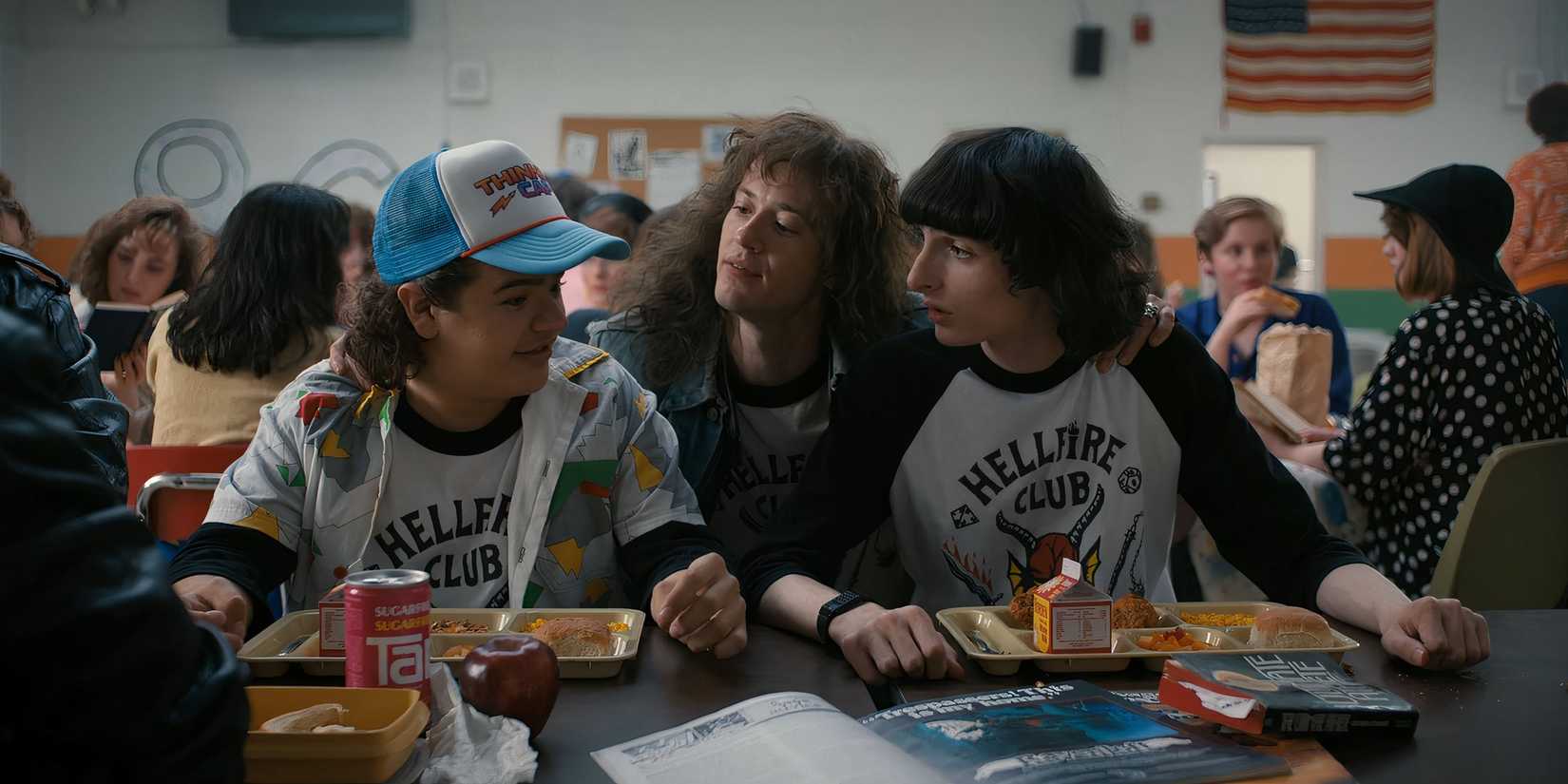 Eddie putting his arms around Dustin and Mike at lunch in Stranger Things