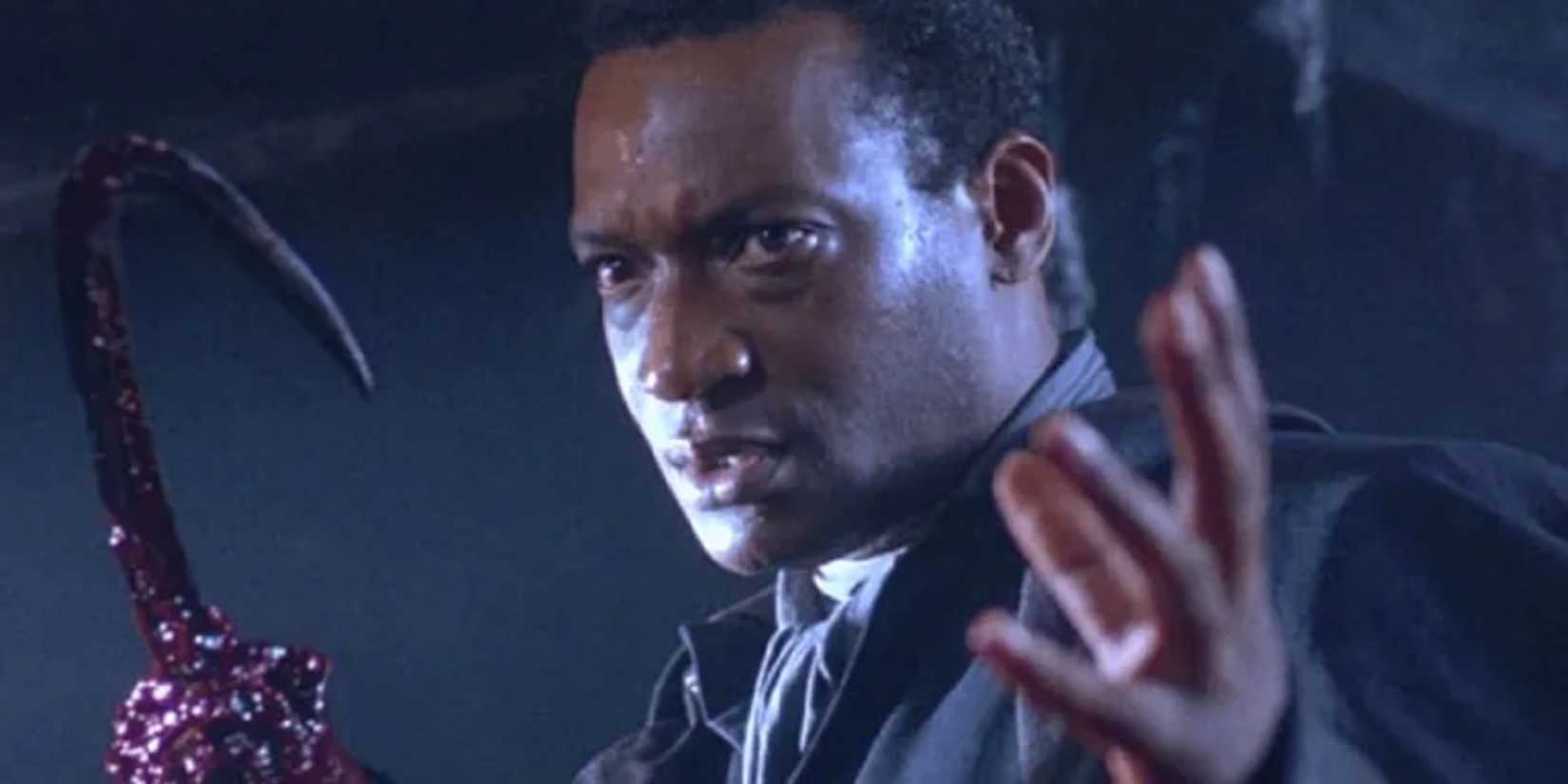 Candyman with his human hand and hook hand raised menacingly 