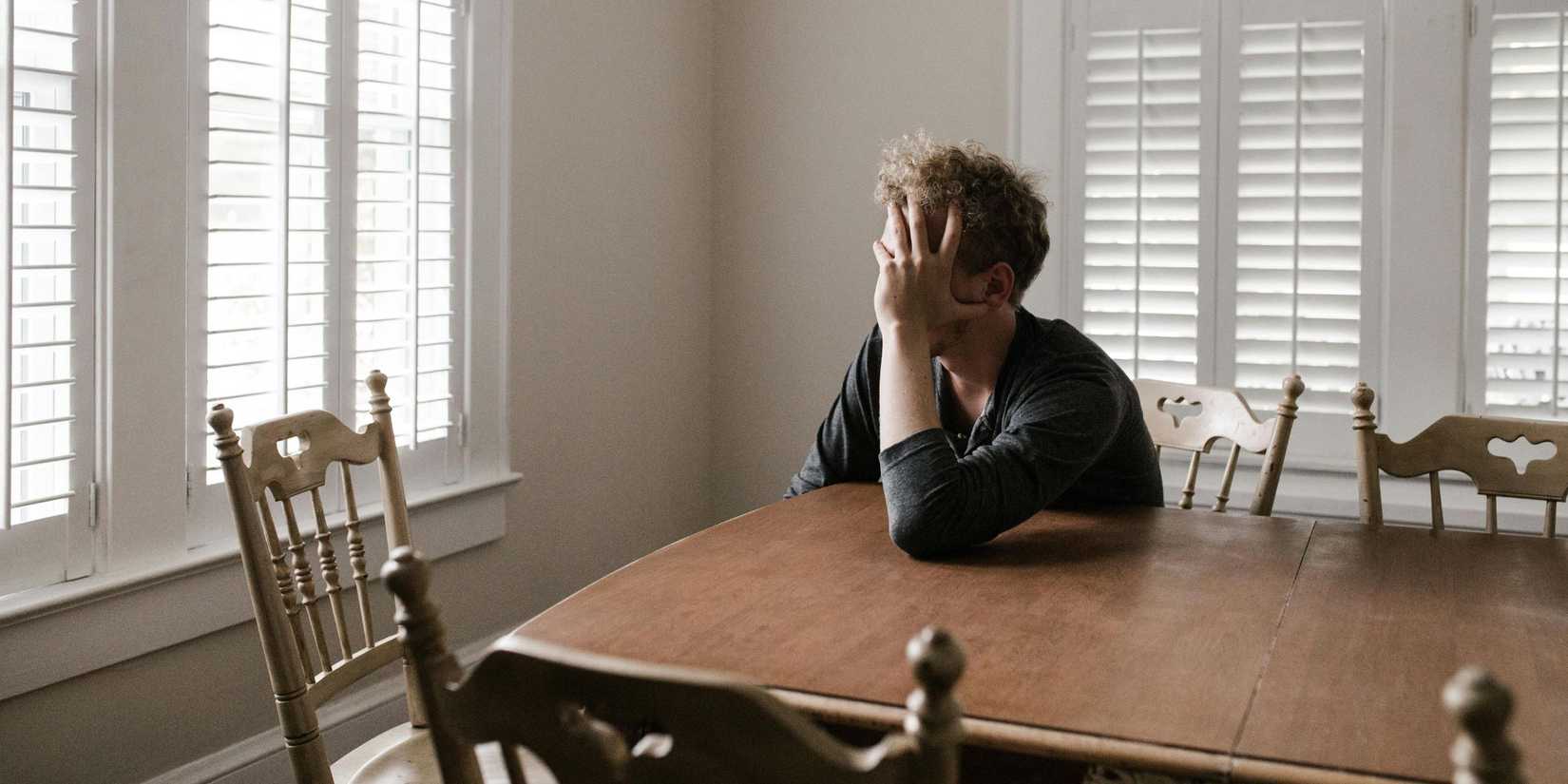 image of a man thinking while staring out a window.