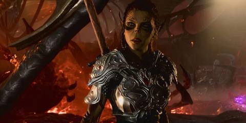 Lae'zel in armor with burning building and fire behind her