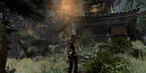 Lara standing outside a ruined temple in Tomb Raider (2013).