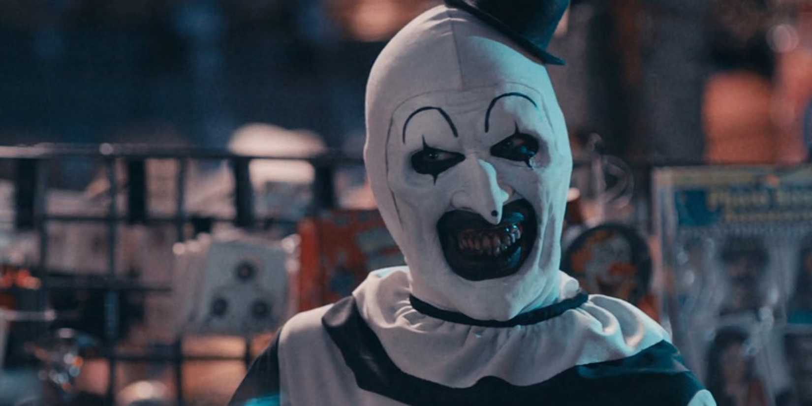 Art the Clown smiling creepily in a costume store 