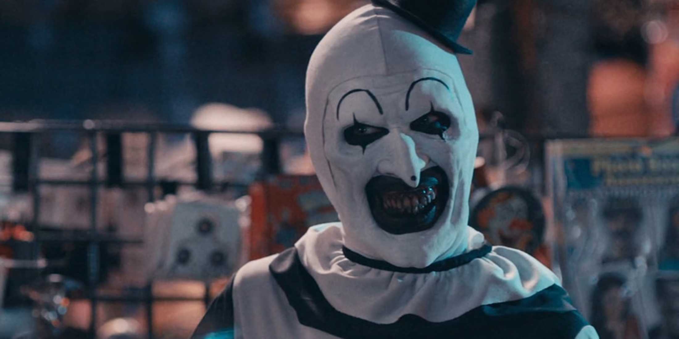 Art the Clown smiling creepily in a costume store
