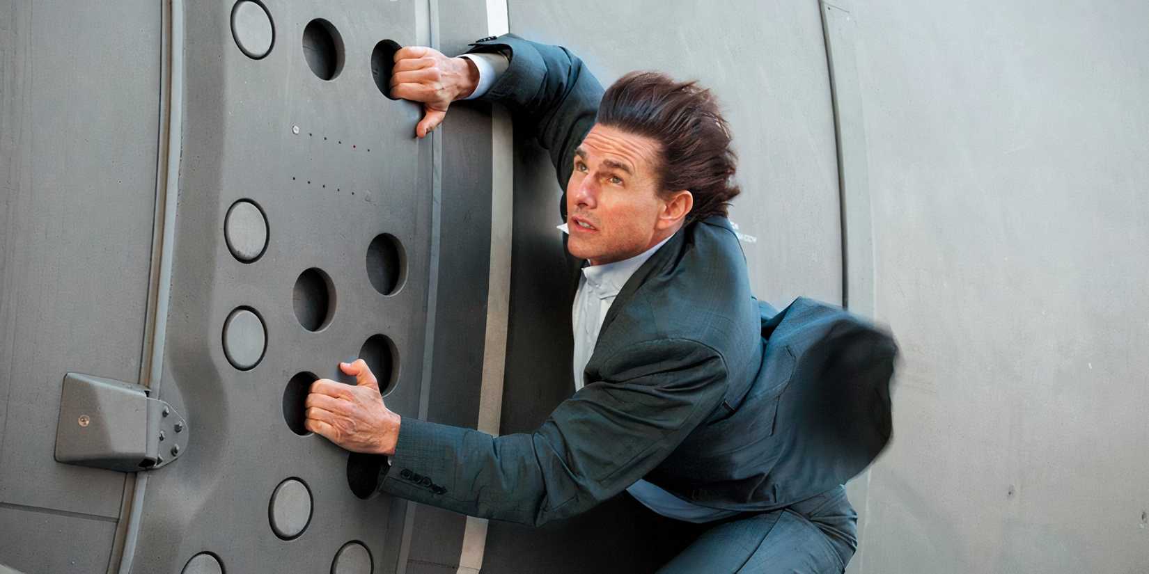 Tom Cruise as Ethan Hunt holding onto a plane in Mission Impossible Rogue Nation