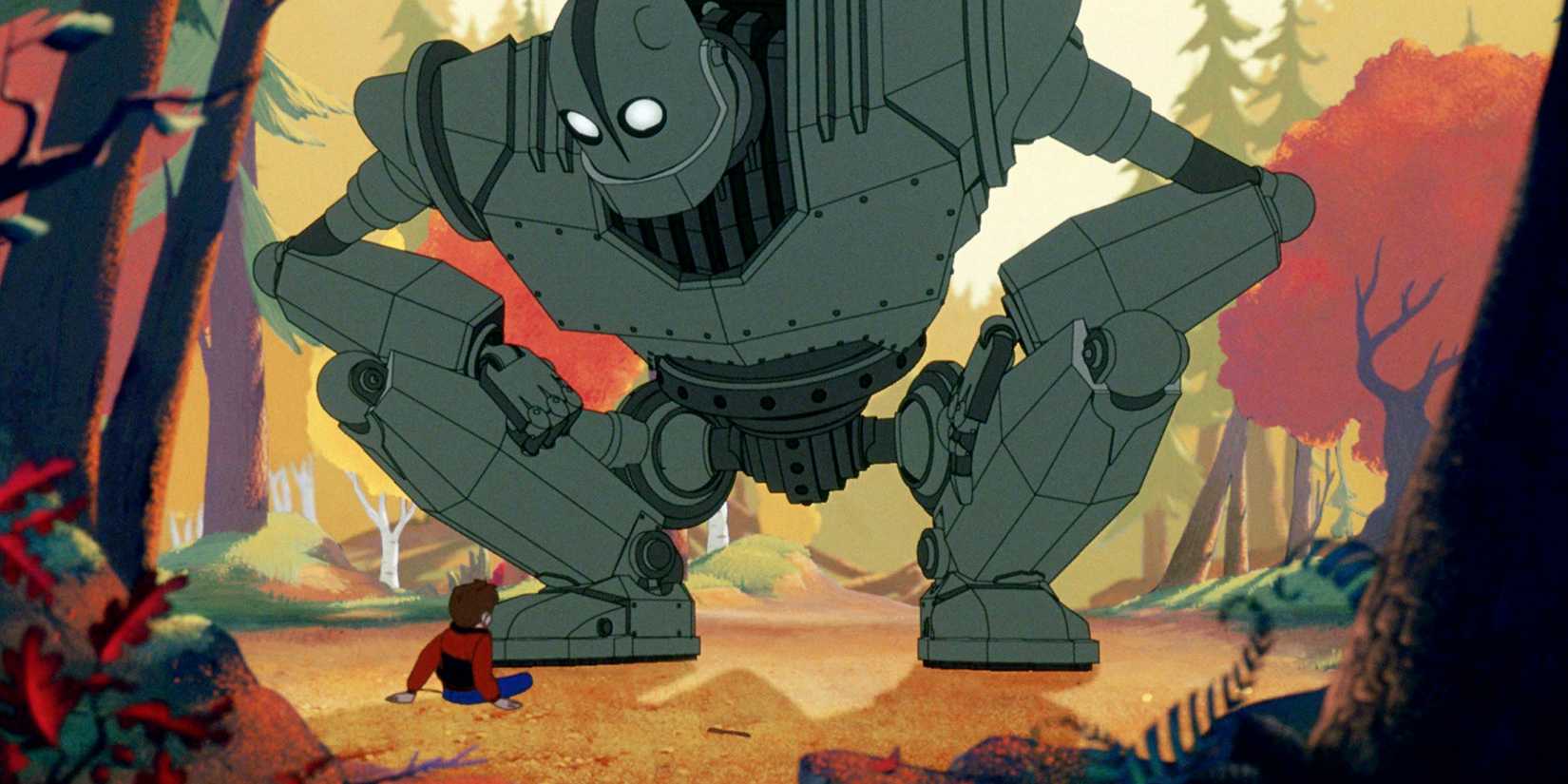 The Iron Giant squats in a forest while looking down at a seated Hogarth Hughes