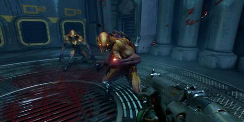 Two agile, glowing-eyed demons approach the player in a futuristic facility filled with blood in Doom (2016) on Switch