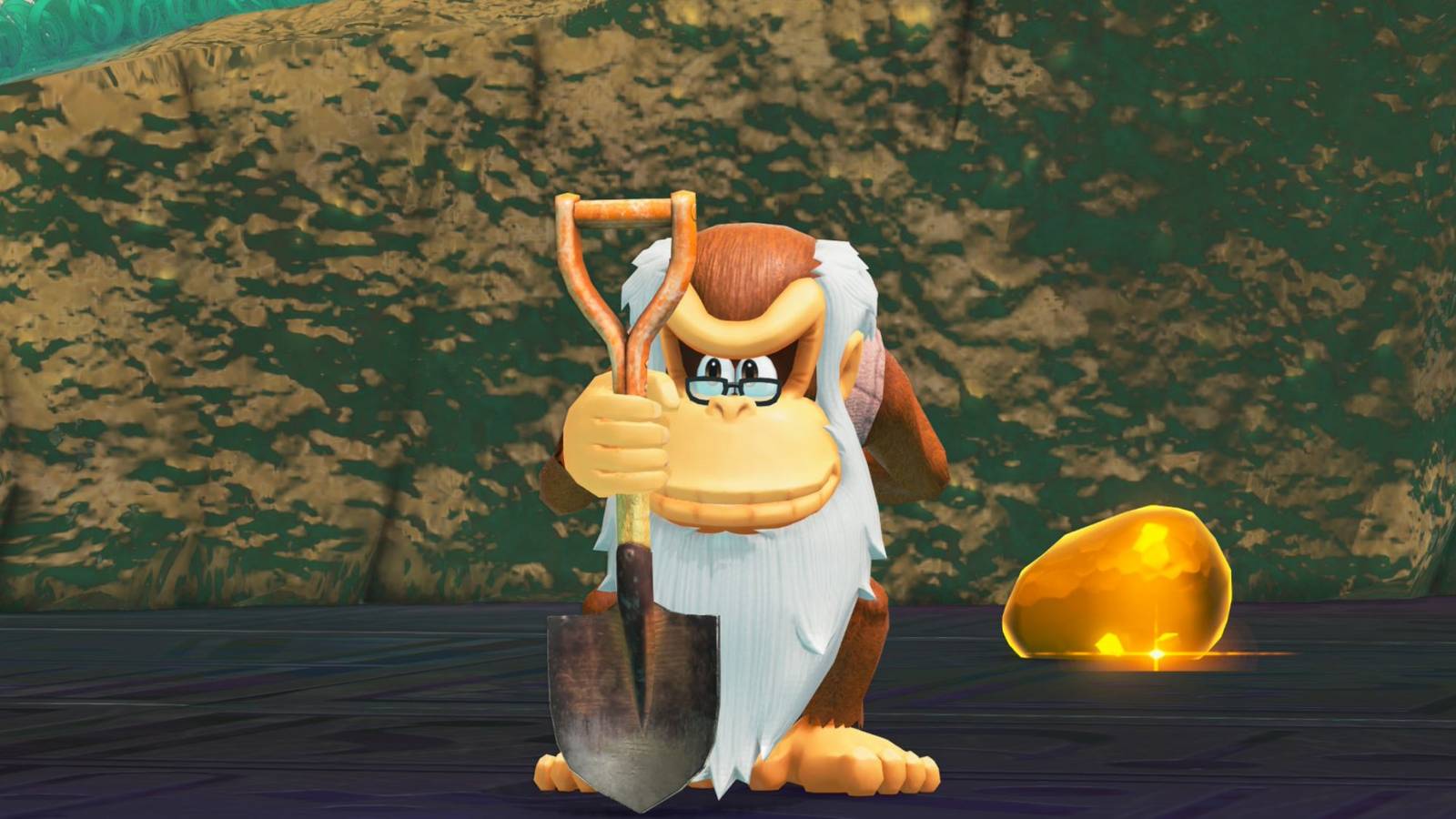Cranky Kong holding a shovel next to a glowing gold gem in Donkey Kong Bananza