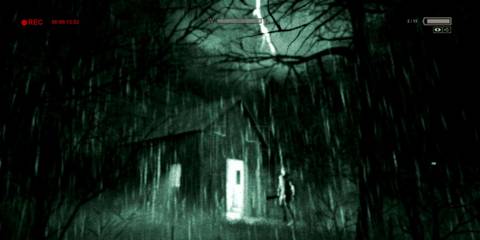 A man standing next to a house in the rain through a camera in Outlast