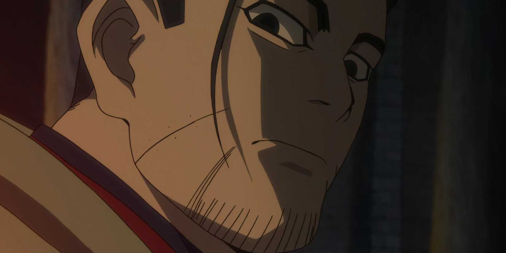 Ogata looks to the side in the low light.