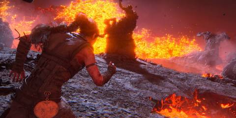 Senua running through a field of fire and lava - Senua's Saga Hellblade 2