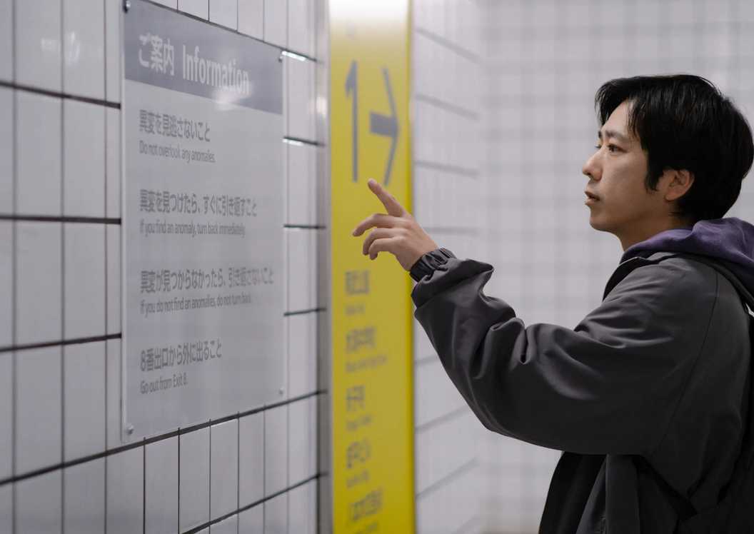 Film Exit 8: Protagonis membaca aturan di film