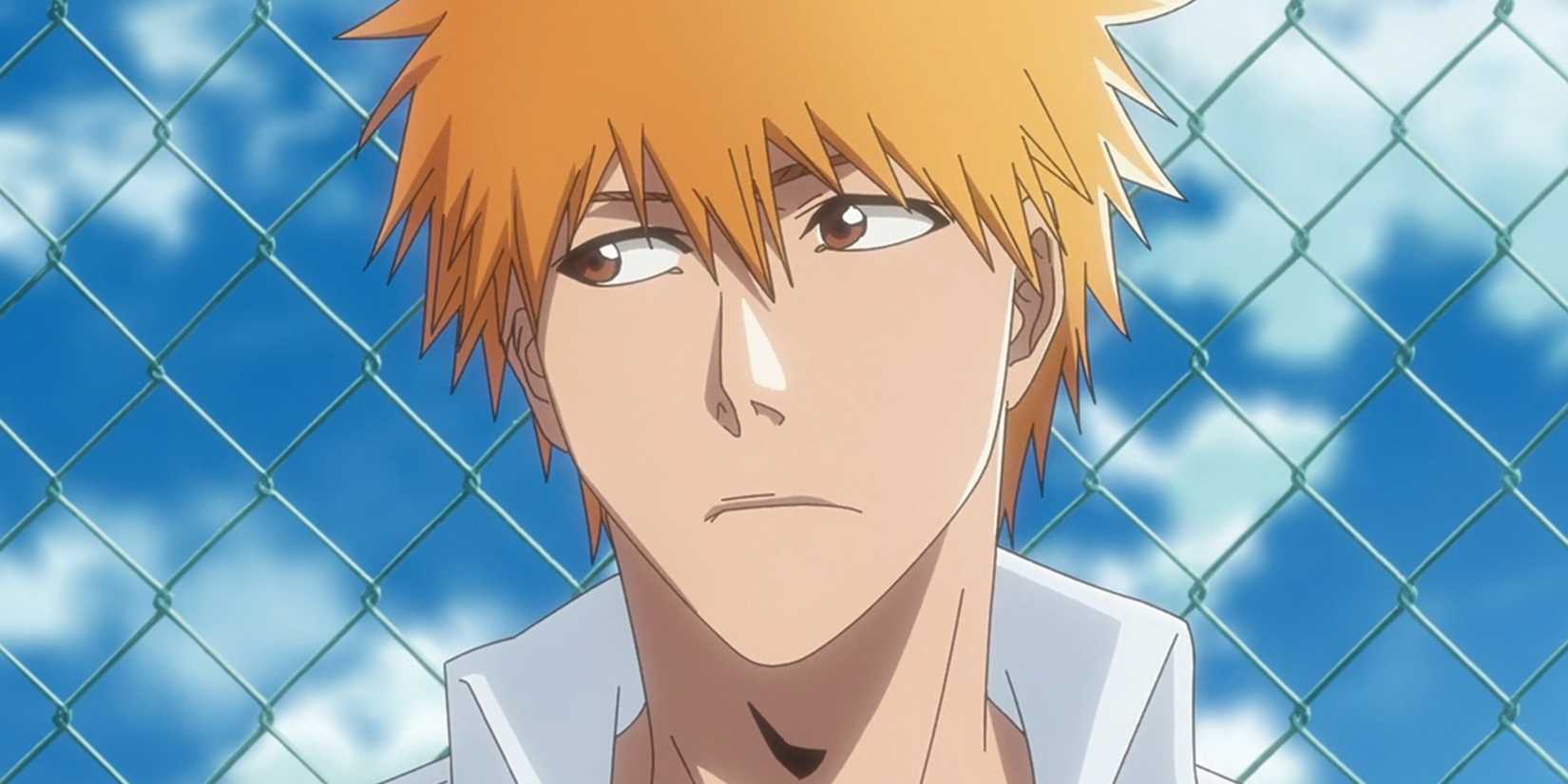 Ichigo looks to the side with a fence behind him.