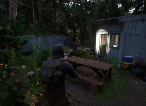 Gubuk dan bangku piknik di Ardem, menunjukkan lingkungan game yang damai namun hancur