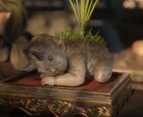 A baby creature from Black Myth Zhong Kui sprouting a plant