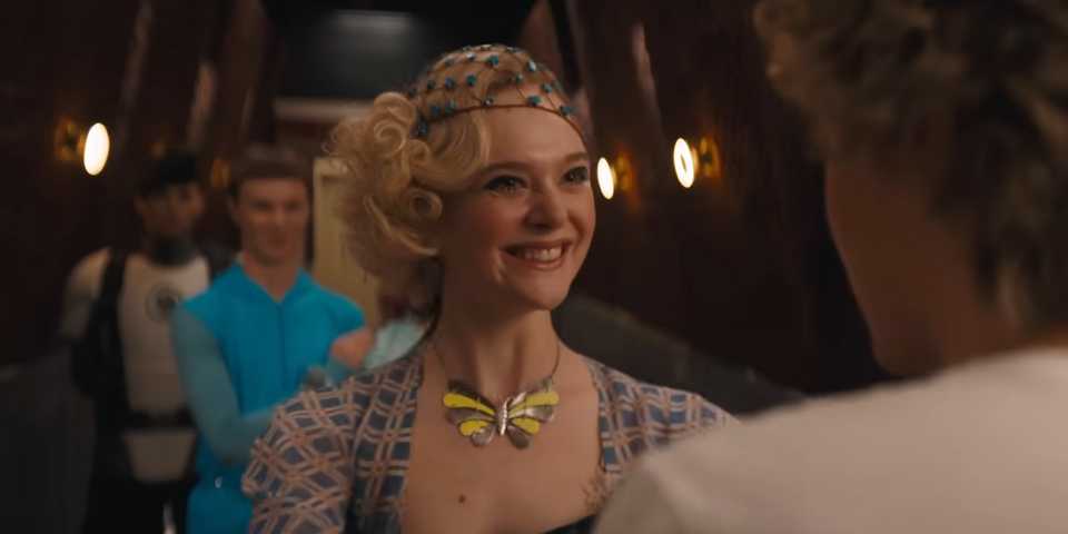 Elle Fanning as Effie Trinket smiles at Haymitch in Sunrise on the Reaping