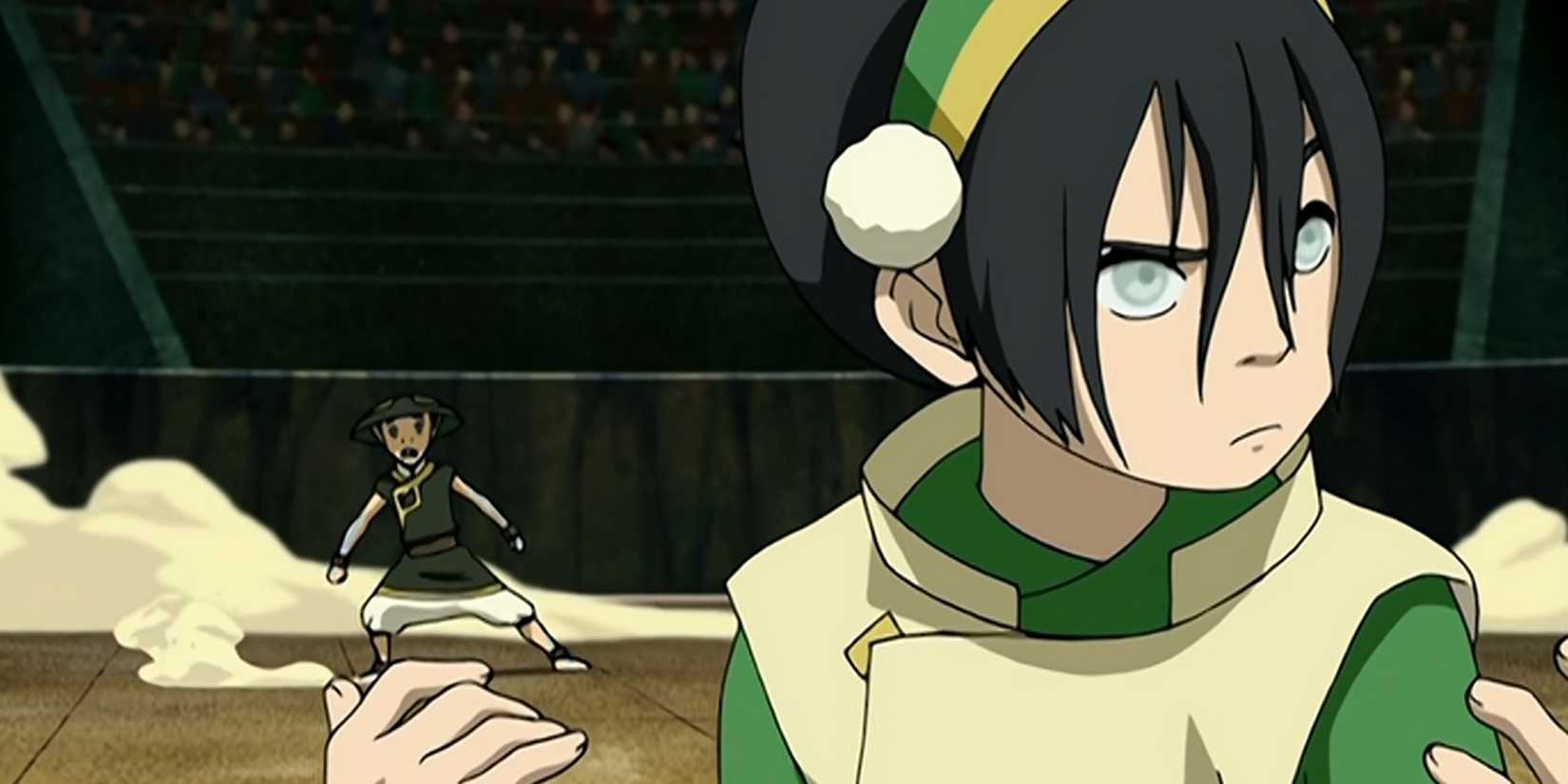 Toph looks around in the arena while Aang is behind her.