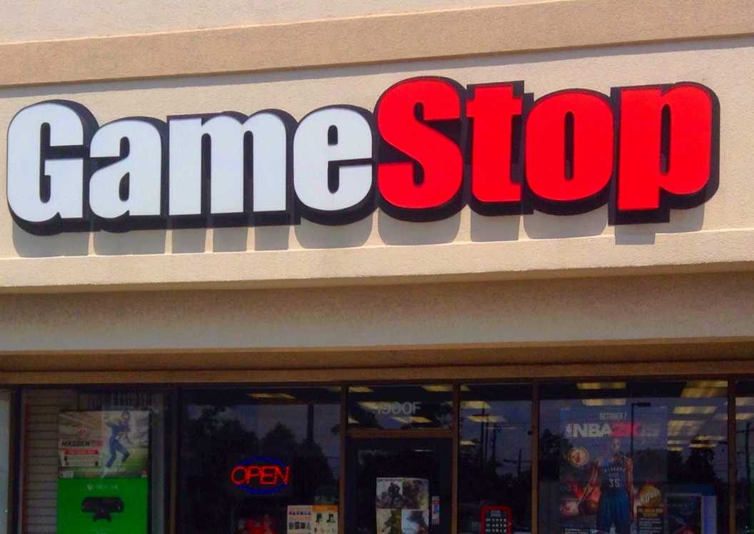 A GameStop storefront during normal business hours, with advertisements for several games and consoles.