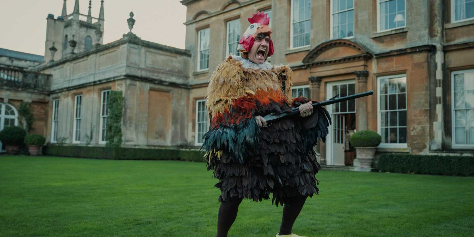 Freddy in the chicken costume holding a gun in The Gentlemen