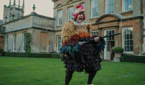 Freddy in the chicken costume holding a gun in The Gentlemen