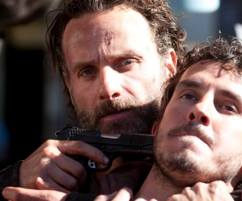 Rick Grimes with a gun to someone's head in The Walking Dead